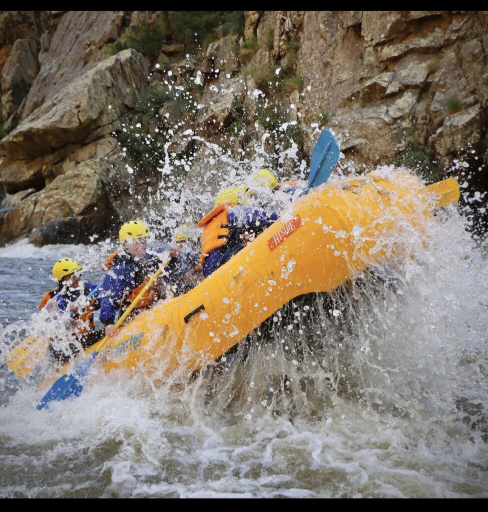 Paddlers in a yellow raft hit a big splashy rapid